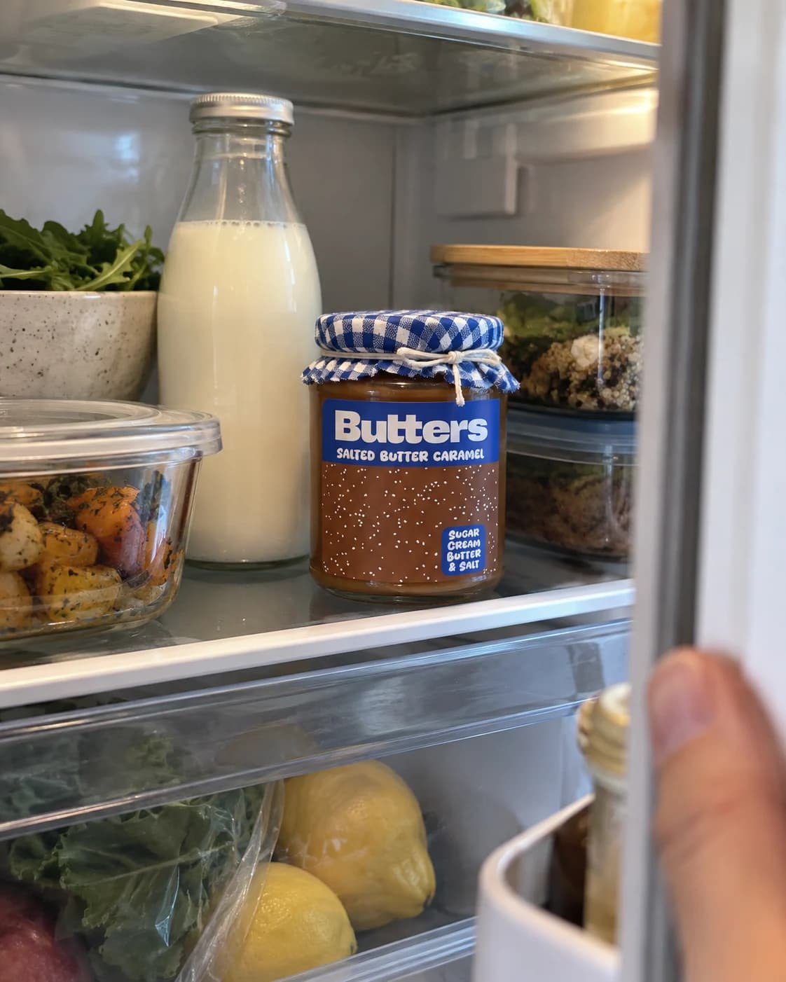 Butters Caramel scatter jar on a fridge shelf, with its blue-and-white cloth cap