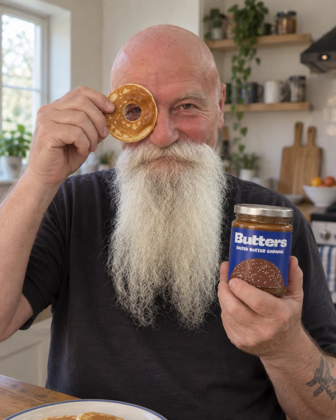 A man holding a Butters jar and peeking through a pancake at breakfast